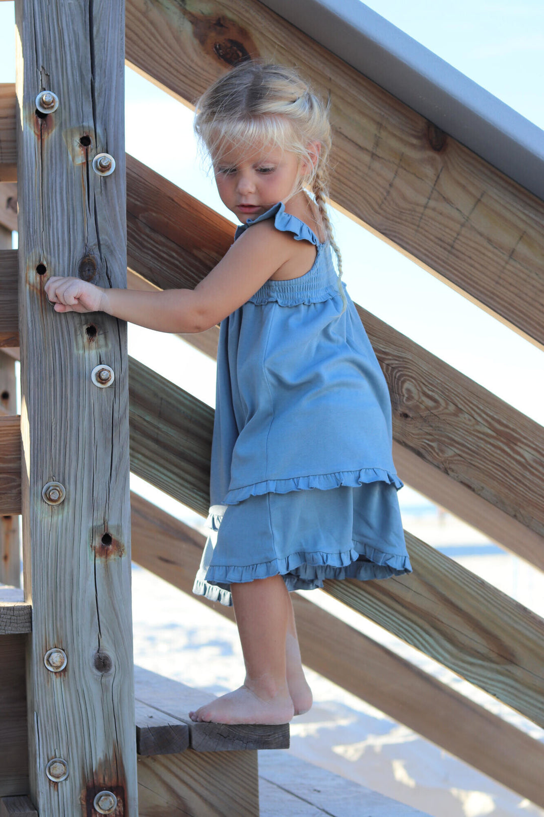 Child wearing Kids' Smocked Summer Dress in Pool.