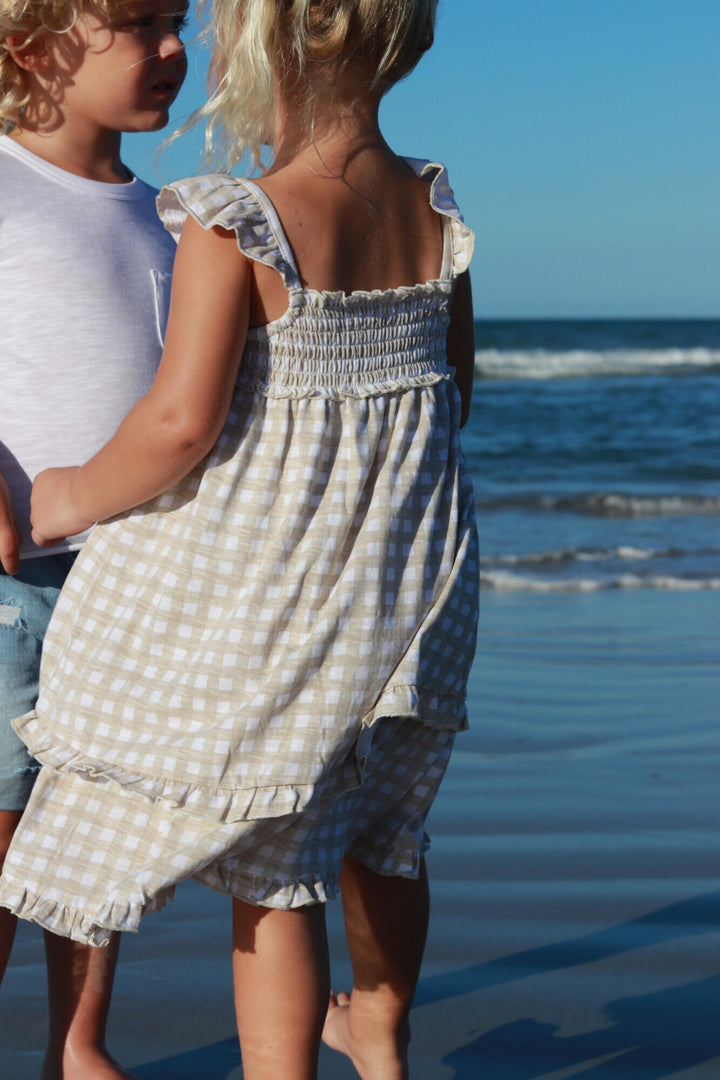 Child wearing Kids' Slub Jersey Smocked Summer Dress in Stone Gingham.