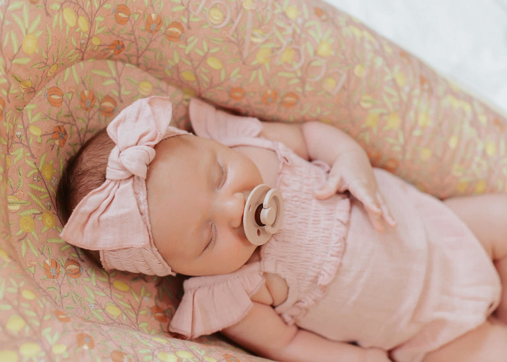 Child wearing Muslin Sleeveless Bodysuit in Carnation.