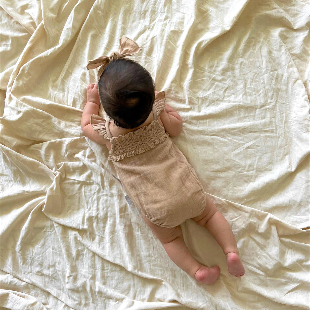 Child wearing Muslin Sleeveless Bodysuit in Wheat.