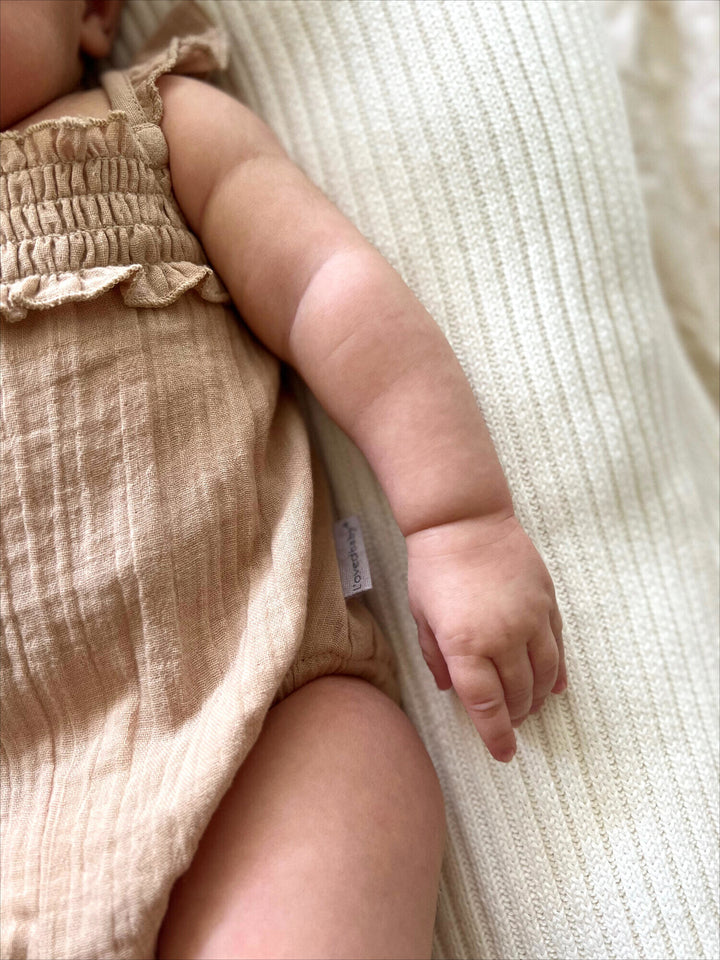 Child wearing Muslin Sleeveless Bodysuit in Wheat.