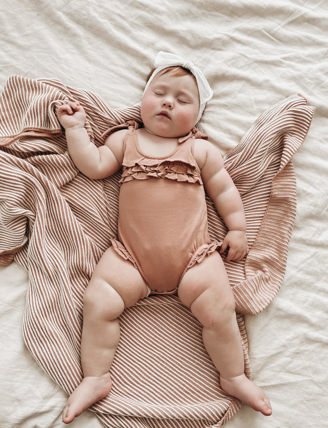 Child wearing Ruffle Bodysuit in Adobe.