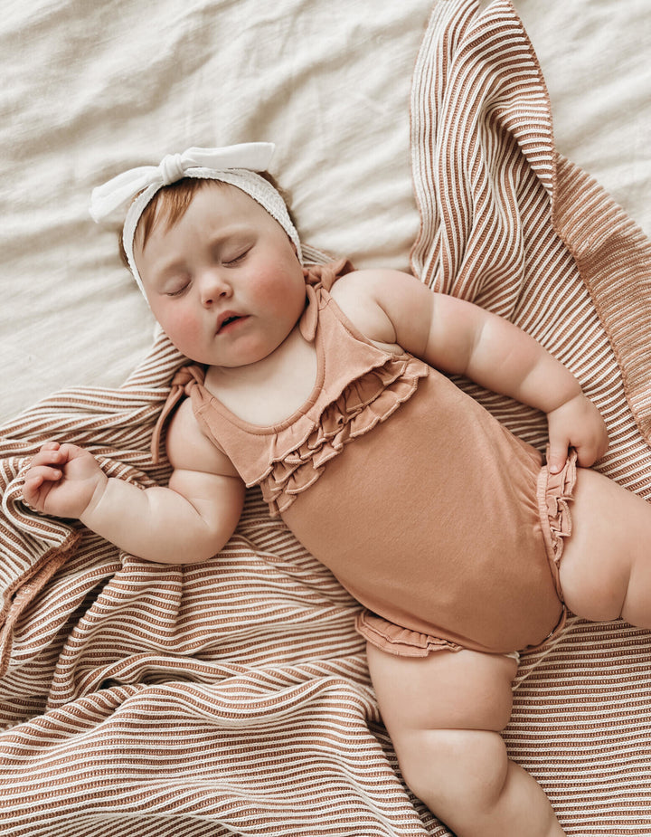 Child wearing Ruffle Bodysuit in Adobe.