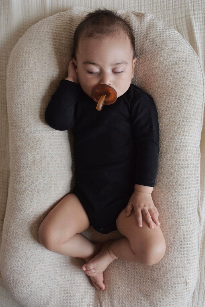 Child wearing Organic Long-Sleeve Bodysuit in Black.