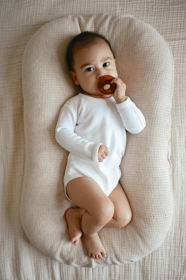 Child wearing Organic Long-Sleeve Bodysuit in White.