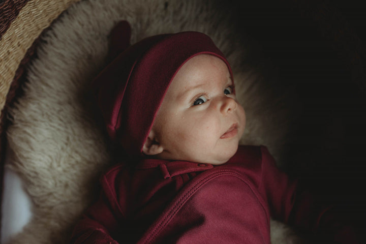 Child wearing Organic Banded Top-Knot Hat in Appleberry.