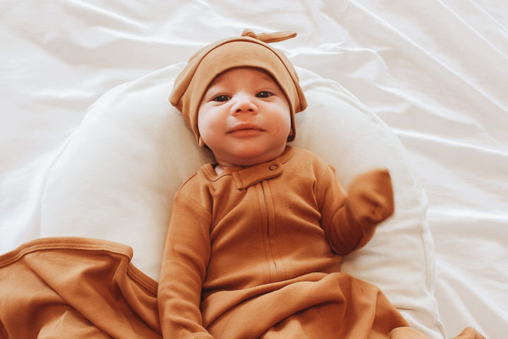 Child wearing Organic Banded Top-Knot Hat in Butterscotch.