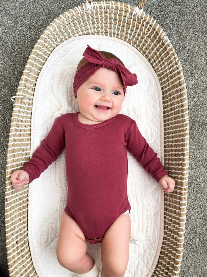 Child wearing Organic Smocked Tie Headband in Appleberry.