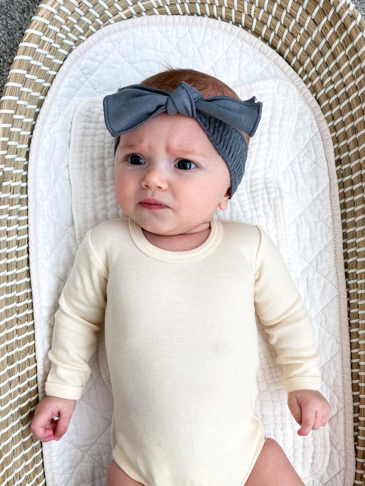 Child wearing Organic Smocked Tie Headband in Moonstone.