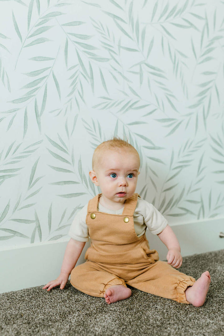 Child wearing French Terry Overall Romper in Adobe.