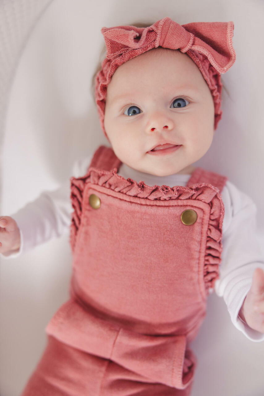 Child wearing French Terry Ruffle Romper in Sienna. Credit: lu.q.leonard