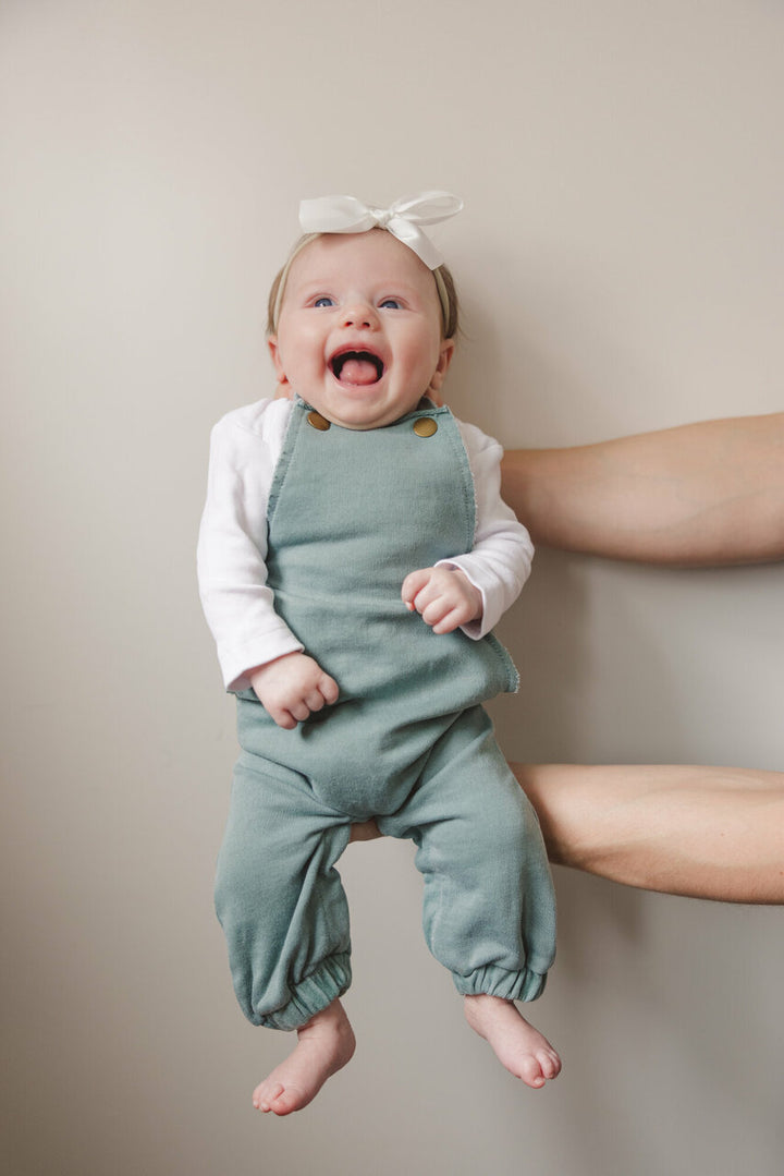 Child wearing French Terry Overall Romper in Jade.