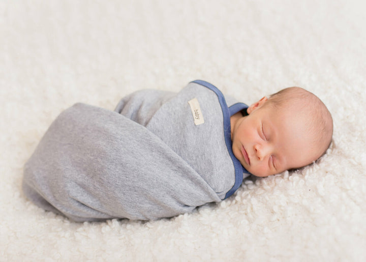 Child wearing Organic Swaddling Blanket in Slate Heather.