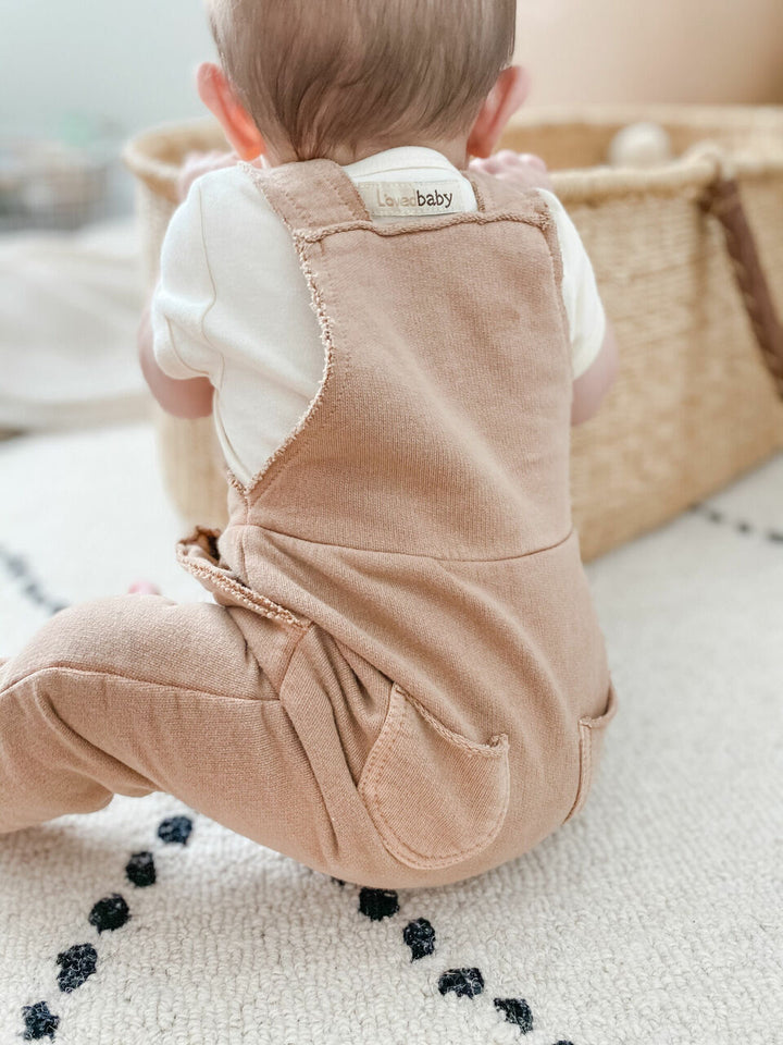 Child wearing French Terry Overall Romper in Adobe.