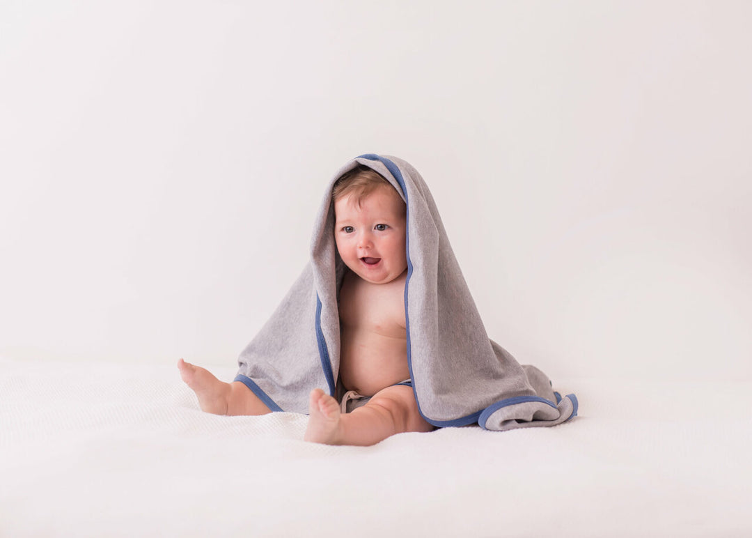 Child wearing Organic Swaddling Blanket in Slate Heather.