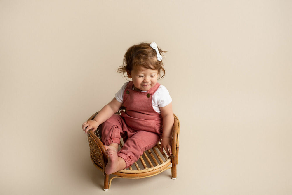 Child wearing French Terry Overall Romper in Sienna.