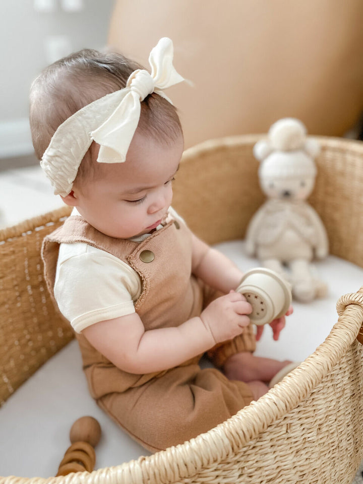 Child wearing French Terry Overall Romper in Adobe.